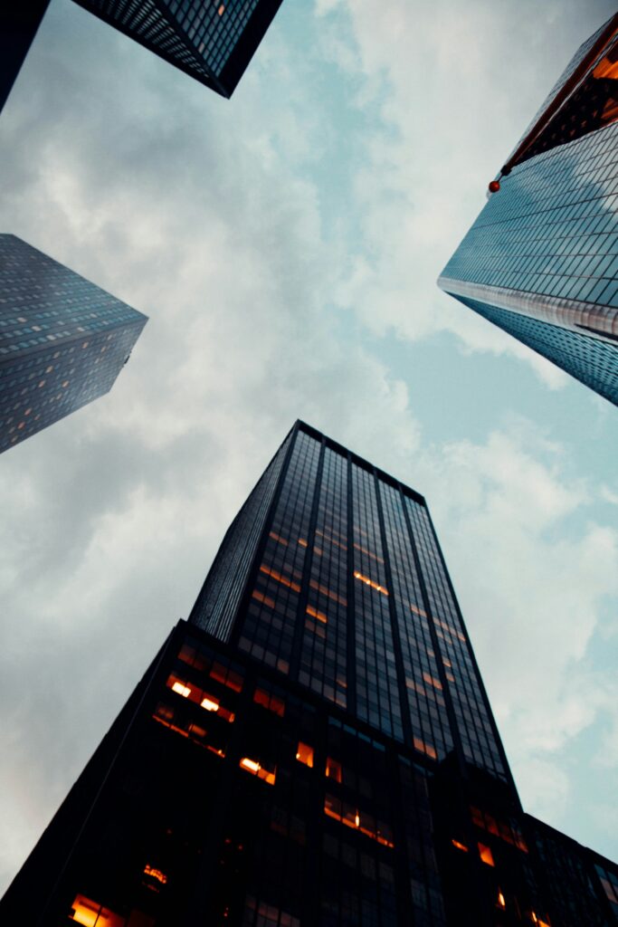 Looking up at towering corporate office buildings at night, symbolizing future business growth and innovation landscapes."