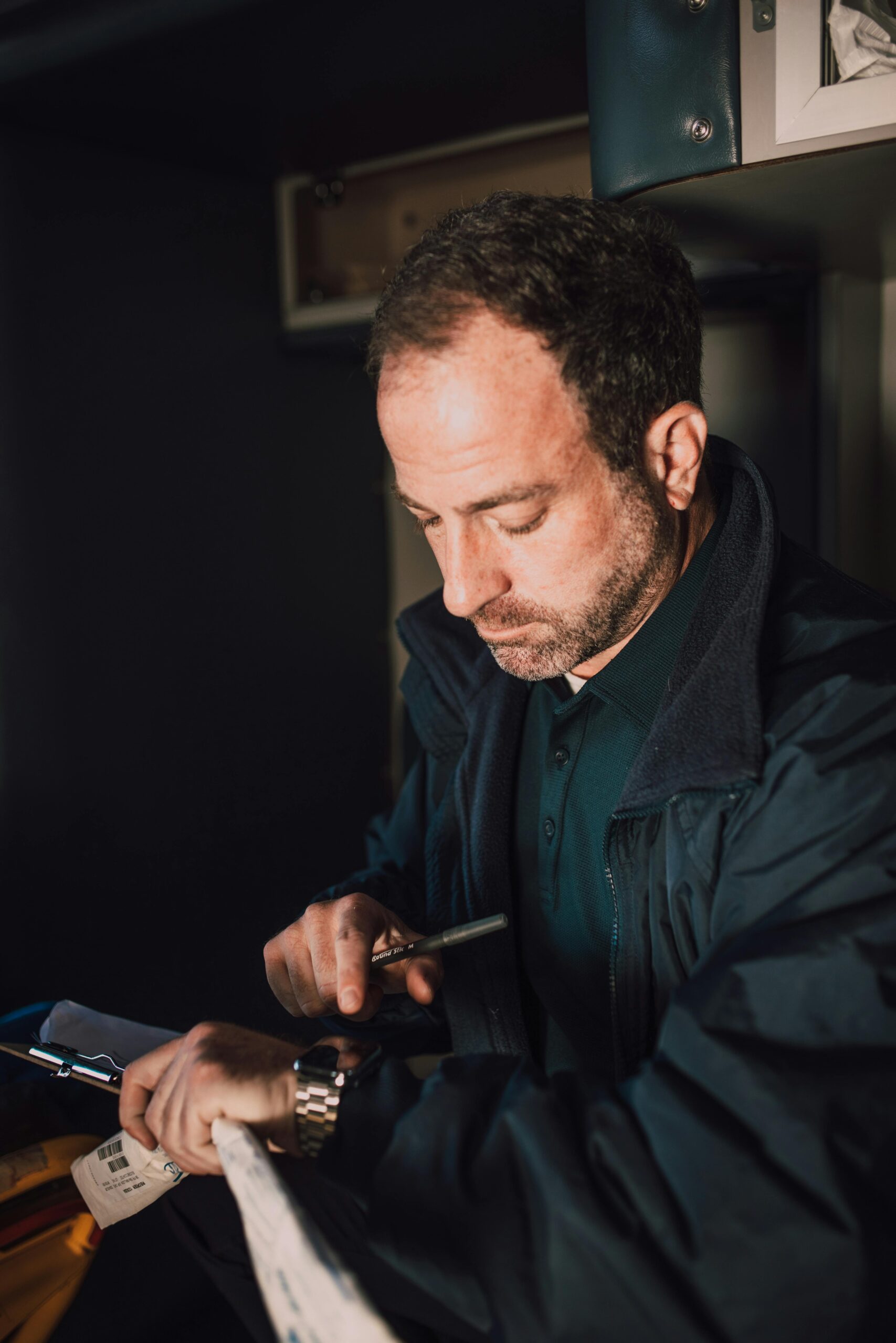 Focused paramedic checking time and documentation indoors.